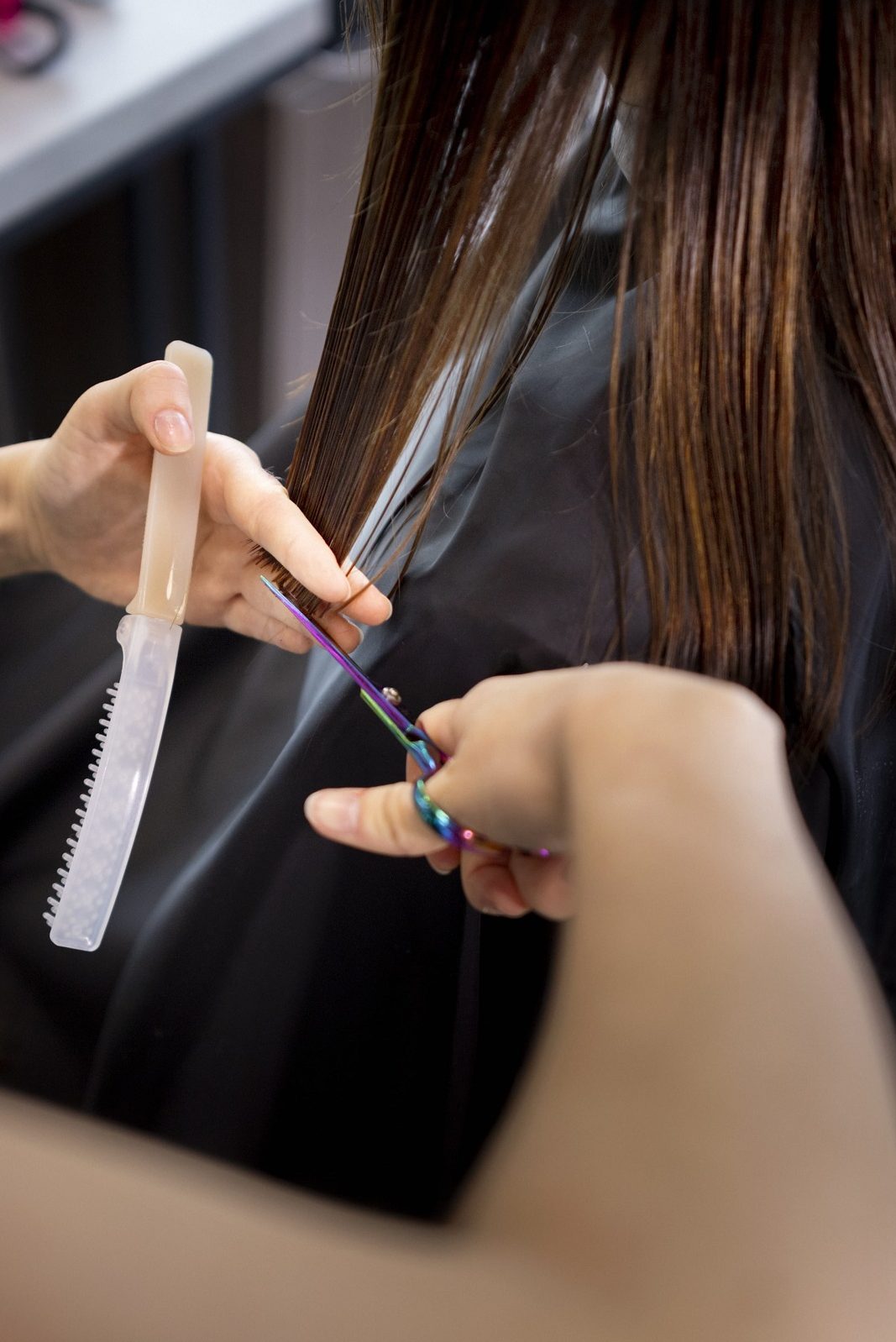 A hair stylist cutting a woman's hair